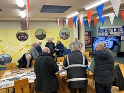 Attendees at living memory event gathered around table looking at memorabilia
